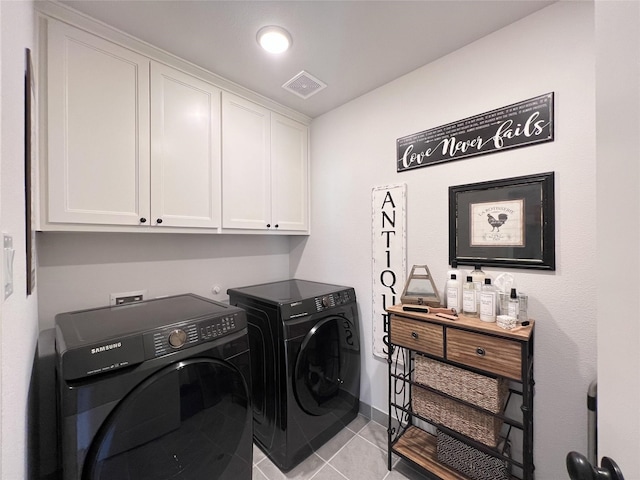 clothes washing area with separate washer and dryer, light tile patterned floors, cabinet space, and visible vents