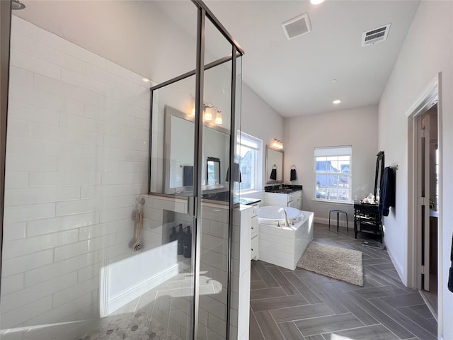 full bathroom featuring visible vents, a shower stall, a garden tub, recessed lighting, and vanity