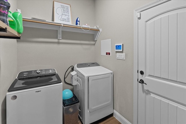 washroom featuring wood finished floors, separate washer and dryer, and laundry area
