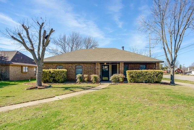 ranch-style home with brick siding, a front lawn, and a shingled roof