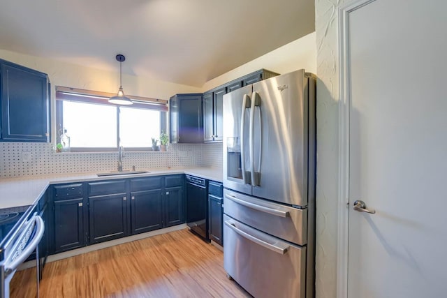 kitchen featuring a sink, blue cabinetry, backsplash, and stainless steel appliances