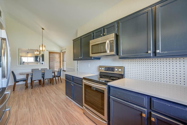 kitchen with lofted ceiling, light wood-style flooring, stainless steel appliances, hanging light fixtures, and light countertops