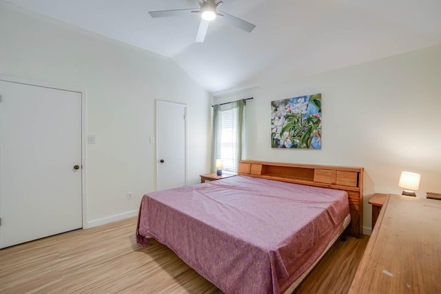 bedroom featuring baseboards, light wood-type flooring, a ceiling fan, and vaulted ceiling