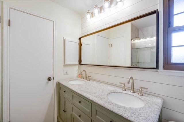 full bath with double vanity, a shower, and a sink