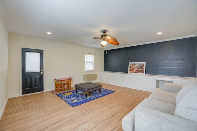 living area featuring a ceiling fan, wood finished floors, a wall unit AC, recessed lighting, and crown molding