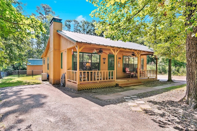 736 Wildwood Trl, Holly Lake Ranch, TX 75765 - view of front of home featuring a ceiling fan, a chimney, metal roof, and central air condition unit