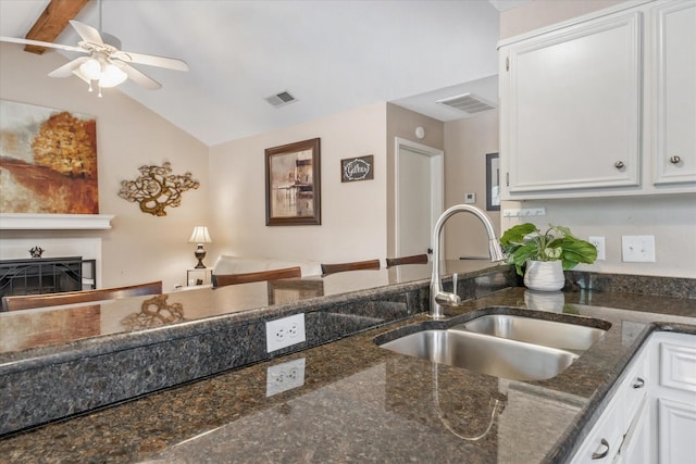 736 Wildwood Trl, Holly Lake Ranch, TX 75765 - kitchen featuring a sink, white cabinets, a ceiling fan, a fireplace, and vaulted ceiling
