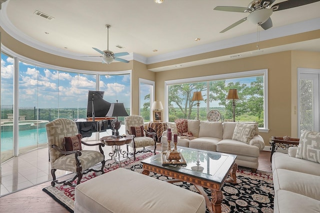 living room featuring crown molding, wood finished floors, visible vents, and ceiling fan