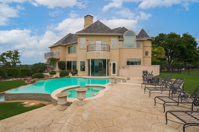 view of swimming pool with a patio, a yard, fence, and a pool with connected hot tub