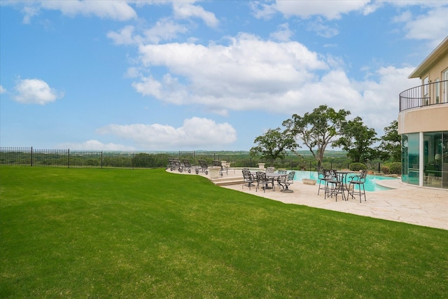 view of yard with a patio, a balcony, a community pool, and fence