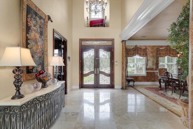 entryway with a notable chandelier, french doors, baseboards, and a towering ceiling