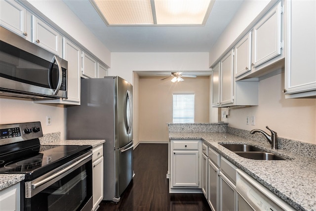 8600 Coppertowne Ln Unit 303C, Dallas, TX 75243 - kitchen featuring stainless steel appliances, a sink, dark wood finished floors, a ceiling fan, and light stone counters