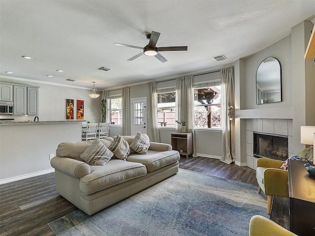 2905 Cabot Ln, Mckinney, TX 75072 - living area with dark wood-style floors, ceiling fan, baseboards, a tile fireplace, and recessed lighting