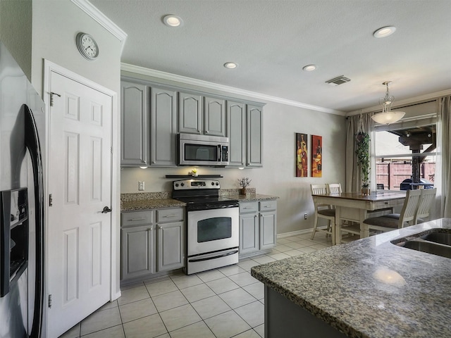 2905 Cabot Ln, Mckinney, TX 75072 - kitchen featuring stainless steel appliances, gray cabinetry, crown molding, light tile patterned flooring, and dark stone counters