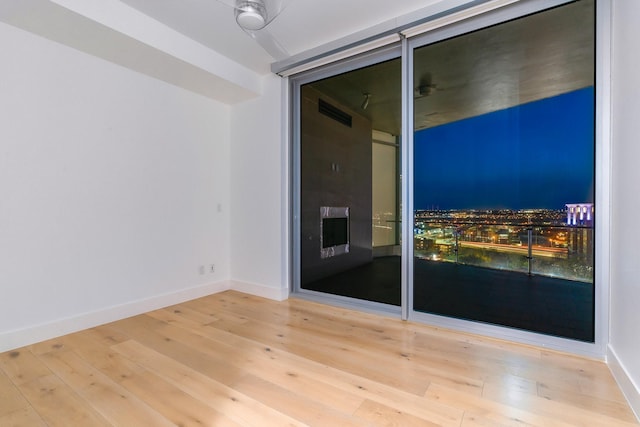 spare room with wood-type flooring and baseboards