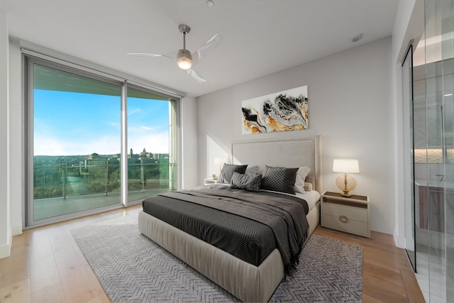 bedroom with floor to ceiling windows, access to exterior, ceiling fan, and light wood-type flooring