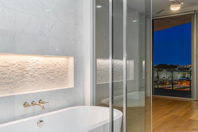 full bath with wood finished floors and a freestanding bath