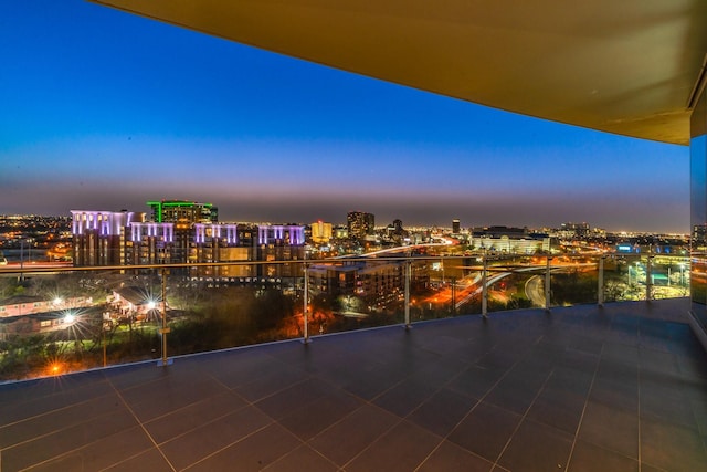 balcony at dusk featuring a city view