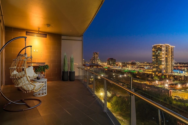 balcony at dusk featuring a view of city