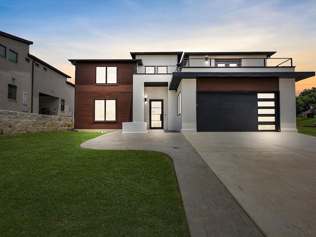 310 Harborview Dr, Rockwall, TX 75032 - contemporary house with concrete driveway, a lawn, an attached garage, stucco siding, and a balcony