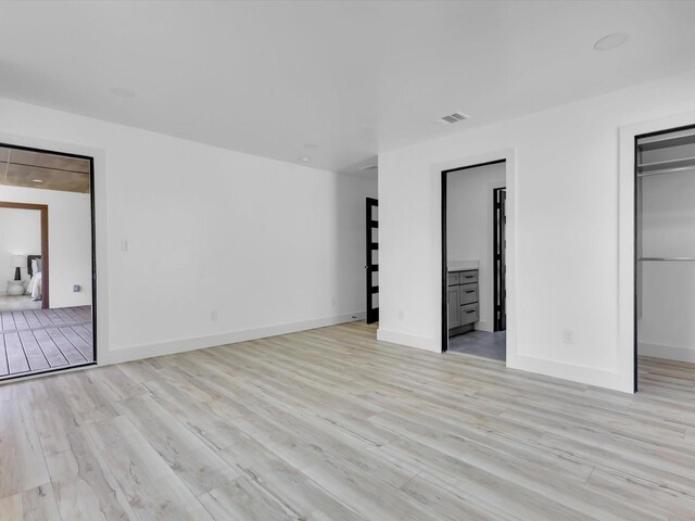 310 Harborview Dr, Rockwall, TX 75032 - unfurnished bedroom with light wood finished floors, a spacious closet, and baseboards