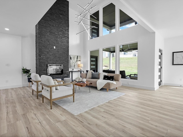310 Harborview Dr, Rockwall, TX 75032 - living area with wood finished floors, a fireplace, a towering ceiling, and baseboards