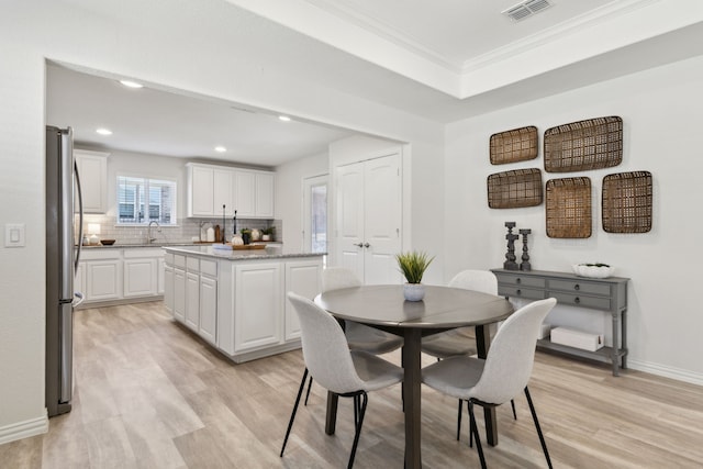 dining space with light wood finished floors, baseboards, ornamental molding, visible vents, and recessed lighting