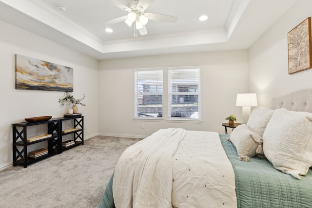 carpeted bedroom with a raised ceiling, baseboards, recessed lighting, ceiling fan, and ornamental molding