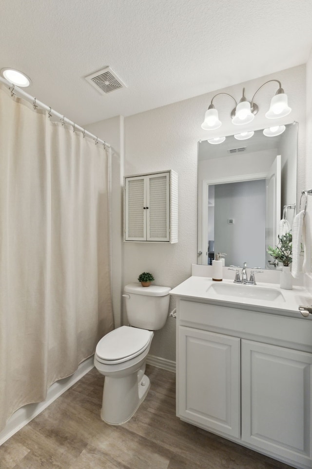 full bathroom with wood finished floors, visible vents, toilet, and vanity