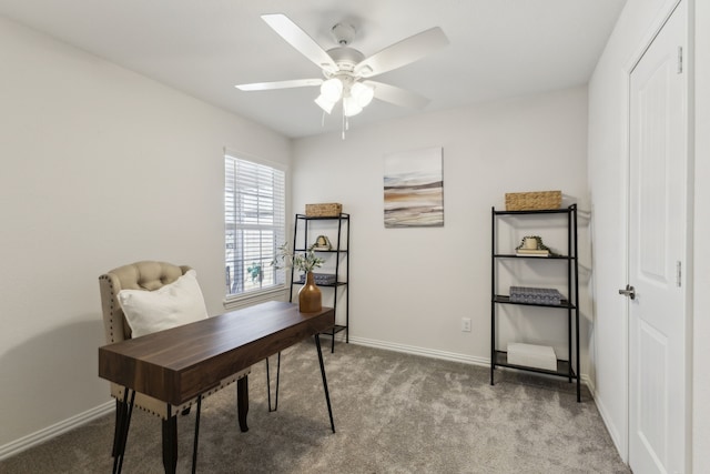 carpeted office space with ceiling fan and baseboards