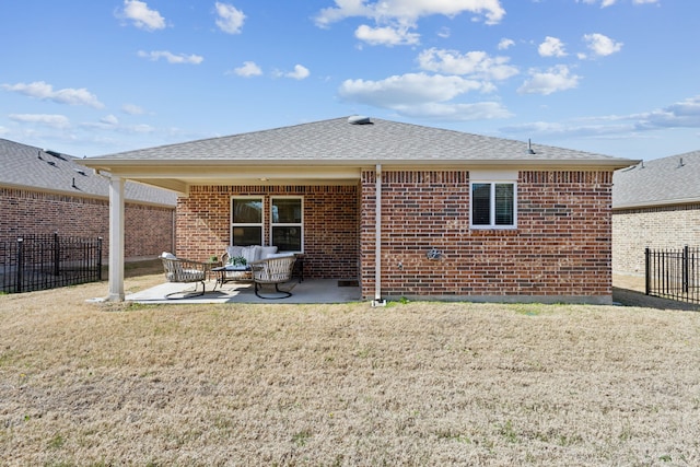 rear view of house featuring fence, brick siding, a patio area, a lawn, and an outdoor living space