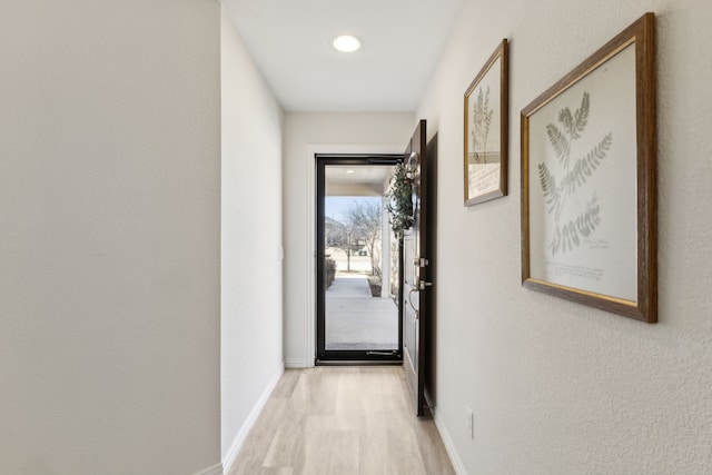 corridor with recessed lighting, light wood-style floors, and baseboards