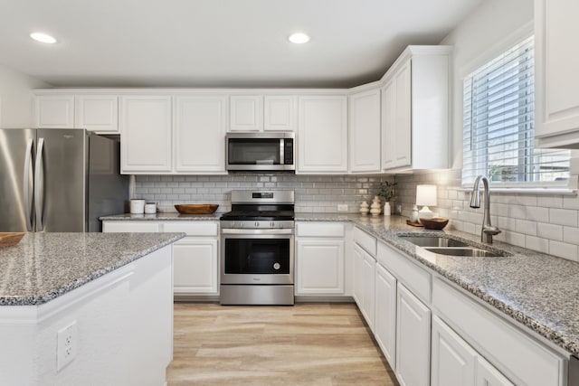 kitchen with white cabinets, stainless steel appliances, and a sink