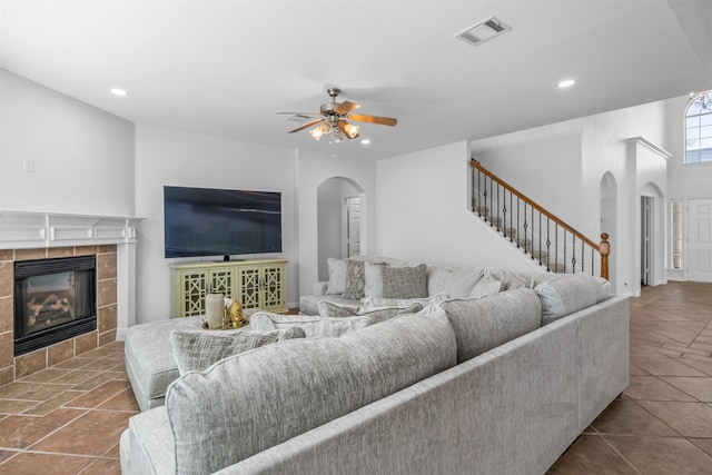 1124 Ginger Trl, Desoto, TX 75115 - tiled living room featuring arched walkways, a ceiling fan, a tile fireplace, and visible vents