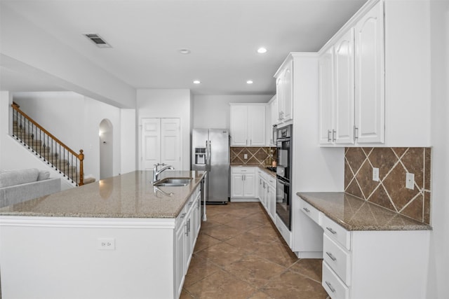 1124 Ginger Trl, Desoto, TX 75115 - kitchen with visible vents, stainless steel fridge, white cabinetry, arched walkways, and a sink