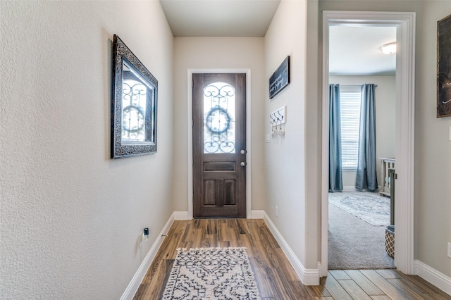 entrance foyer featuring baseboards and wood finished floors