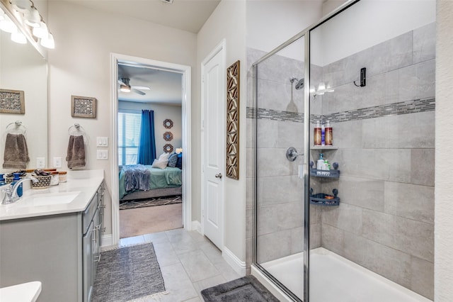 ensuite bathroom with tile patterned flooring, a shower stall, ensuite bathroom, vanity, and a ceiling fan