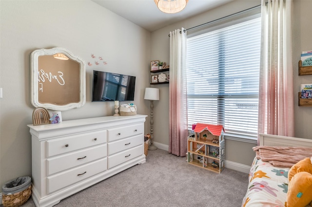 bedroom with light colored carpet and baseboards