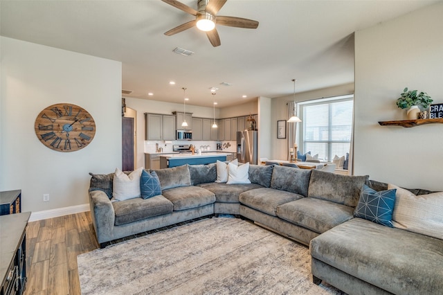 living room with wood finished floors, baseboards, visible vents, recessed lighting, and ceiling fan