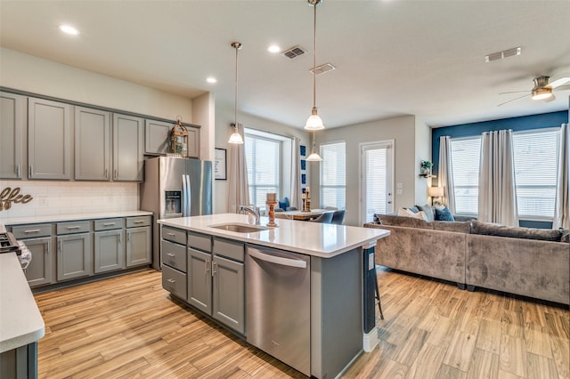 kitchen featuring open floor plan, gray cabinetry, visible vents, and stainless steel appliances