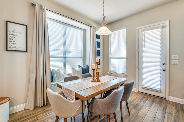 dining space with a wealth of natural light, baseboards, and wood finished floors