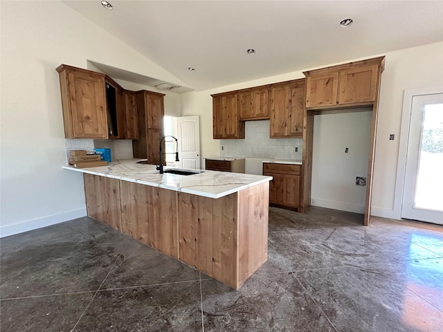 TBD5 Cowley Rd, Whitt, TX 76486 - kitchen featuring a peninsula, lofted ceiling, decorative backsplash, and brown cabinetry
