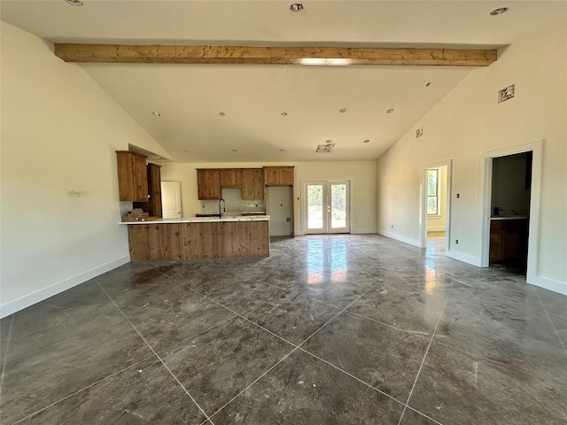 TBD5 Cowley Rd, Whitt, TX 76486 - kitchen with beamed ceiling, a peninsula, high vaulted ceiling, brown cabinetry, and light countertops