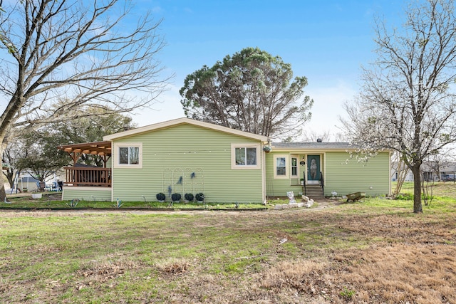 rear view of property featuring entry steps and a yard