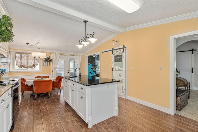 kitchen with dark wood finished floors, a barn door, stainless steel electric range, and french doors