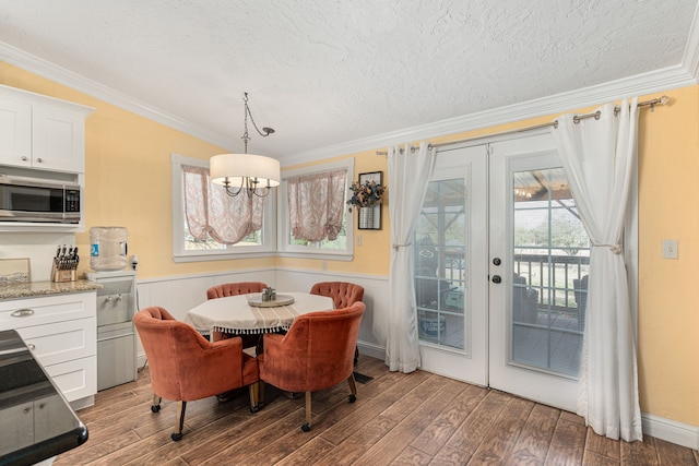 dining room with french doors, wood finished floors, and crown molding