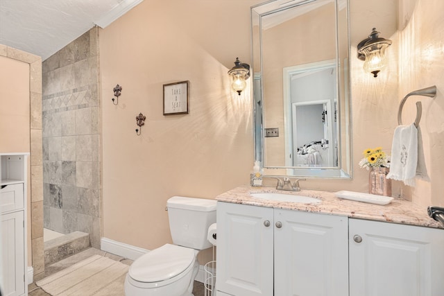 bathroom with toilet, ornamental molding, baseboards, walk in shower, and vanity