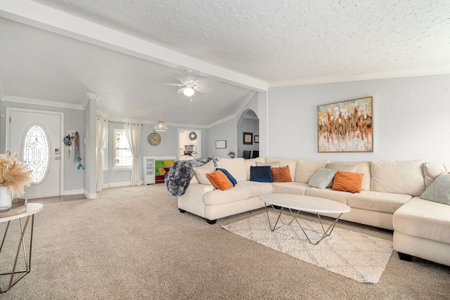 living area featuring ornamental molding, lofted ceiling with beams, a textured ceiling, carpet, and ceiling fan