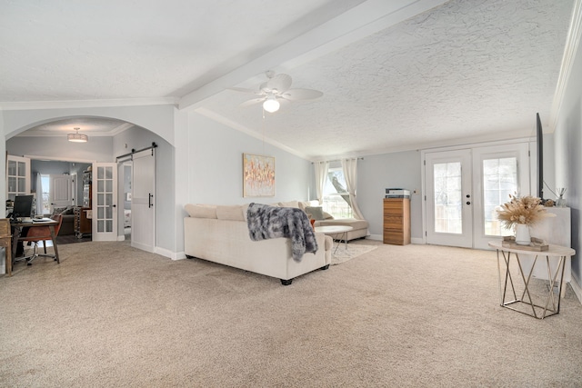 living area with carpet flooring, french doors, vaulted ceiling with beams, and a barn door