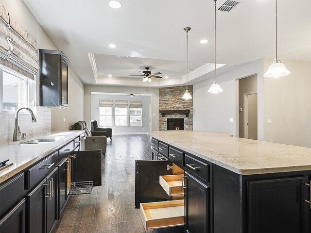 1722 Port Royal Ln, Frisco, TX 75036 - kitchen with a sink, dark cabinets, a ceiling fan, a center island, and a raised ceiling